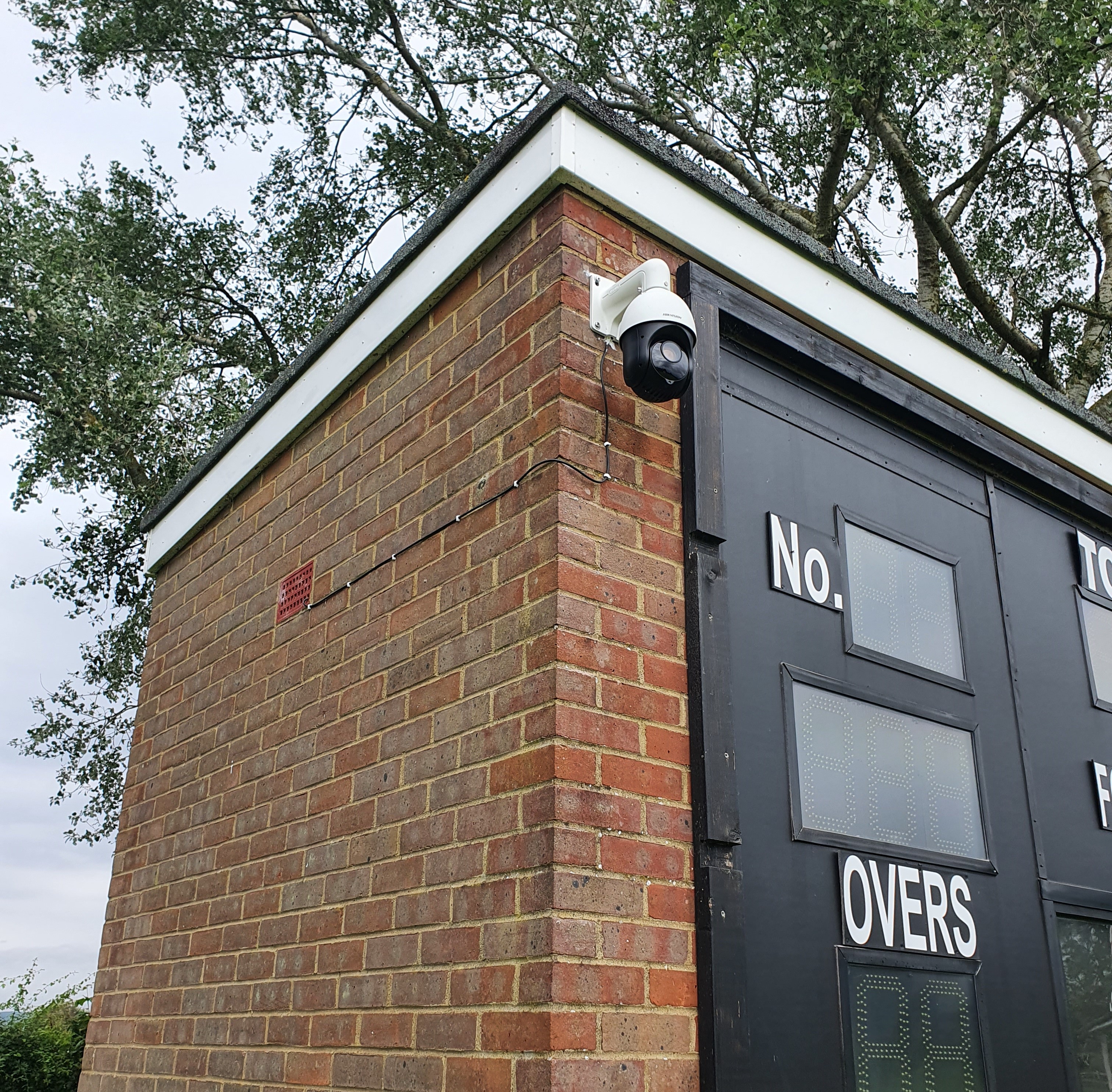 NV Play live streaming permanent install camera on a brick building next to scoreboard